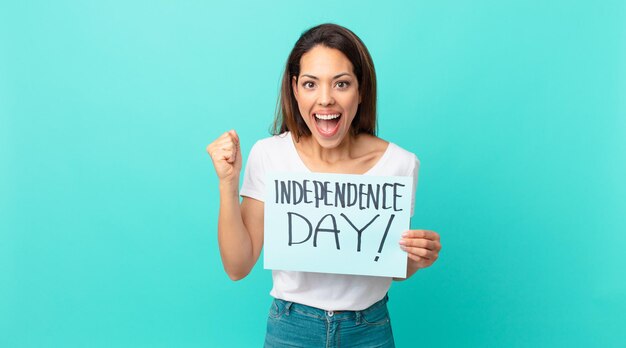 Young hispanic woman feeling shocked,laughing and celebrating success. independence day concept