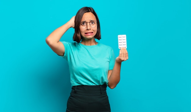 Young hispanic woman feeling stressed, worried, anxious or scared, with hands on head, panicking at mistake