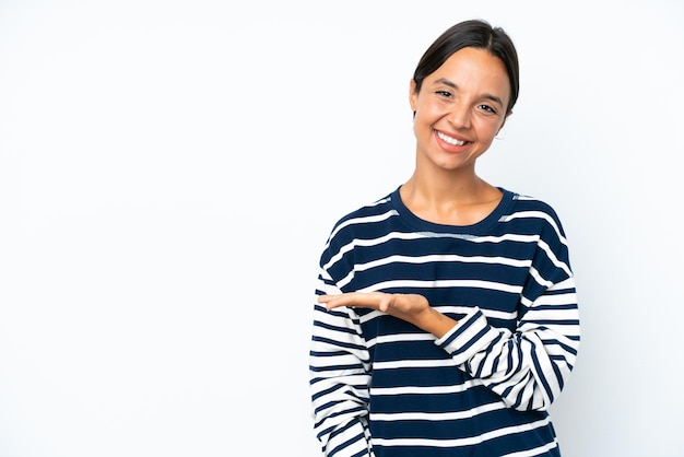 Young hispanic woman isolated on white background presenting an idea while looking smiling towards