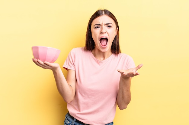 Young hispanic woman looking angry, annoyed and frustrated. empty bowl concept