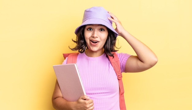 Young hispanic woman looking happy, astonished and surprised. back to school concept