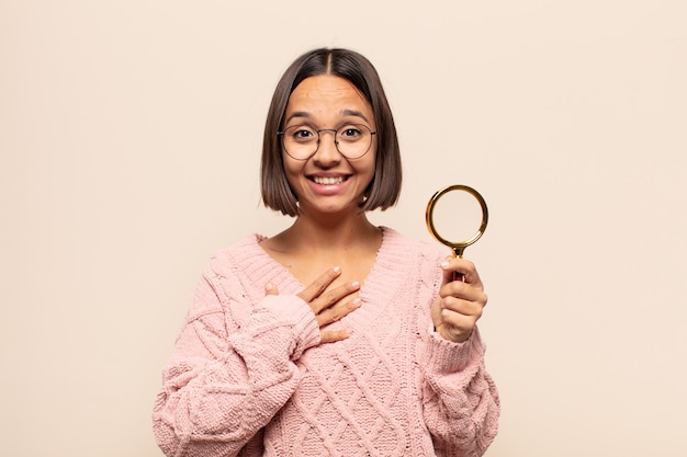 Young hispanic woman looking happy, surprised, proud and excited, pointing to self