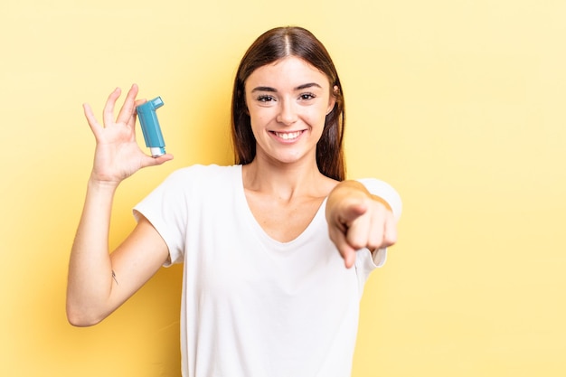 Young hispanic woman pointing at camera choosing you asthma concept