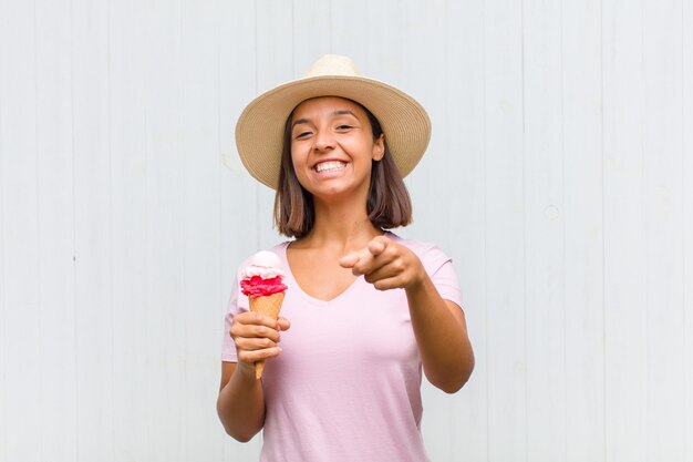 Young hispanic woman pointing at camera with a satisfied, confident, friendly smile, choosing you