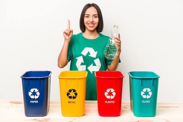 Young hispanic woman recycling plastic isolated on white background