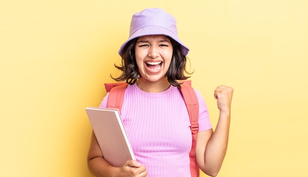 Young hispanic woman shouting aggressively with an angry expression. back to school concept