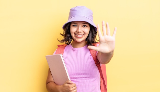 Young hispanic woman smiling and looking friendly, showing number five. back to school concept