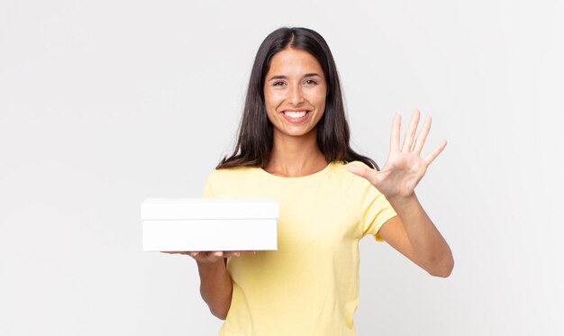 Young hispanic woman smiling and looking friendly showing number five