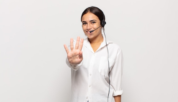 Young hispanic woman smiling and looking friendly, showing number four or fourth with hand forward, counting down