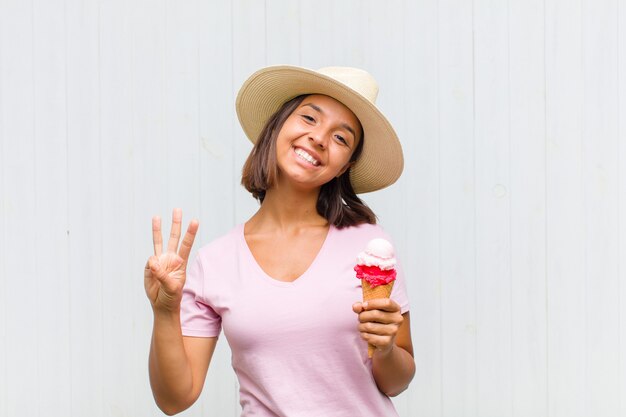 Young hispanic woman smiling and looking friendly, showing number two or second with hand forward, counting down