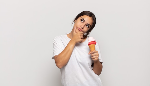 Young hispanic woman thinking, feeling doubtful and confused, with different options, wondering which decision to make