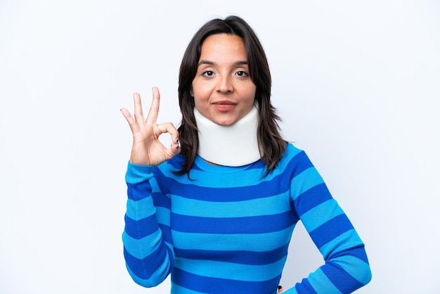 Young hispanic woman wearing neck brace isolated on white background showing ok sign with fingers