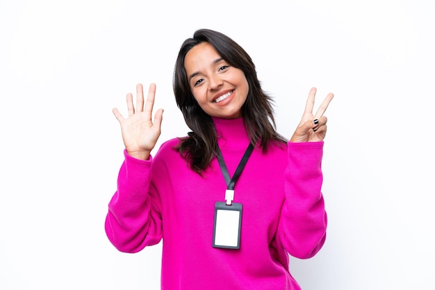 Young hispanic woman with ID card isolated on white background counting seven with fingers