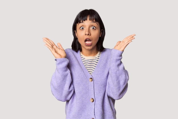 Young Hispanic woman with short black hair in studio celebrating a victory or success