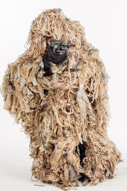 Young hunter with a Ghillie suit and rifle hunting and people concept image isolated on white background