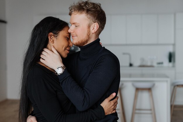 Young husband gently hugs his wife in the kitchen