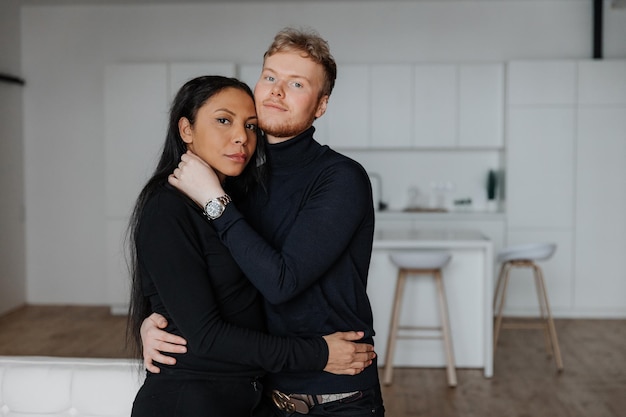 Young husband gently hugs his wife in the living room