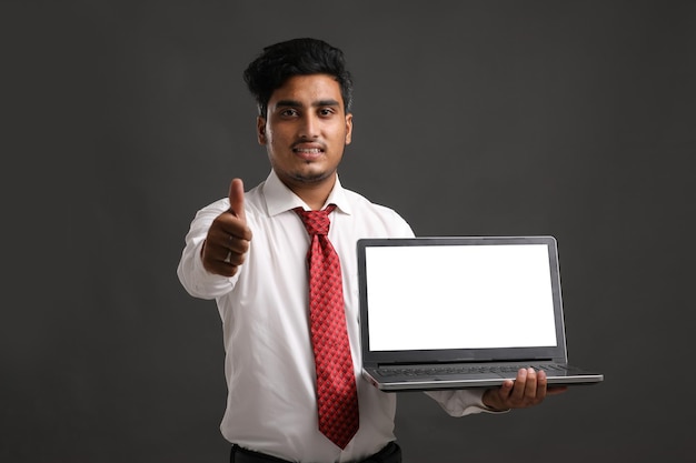 Young india student, banker or employee showing laptop screen.