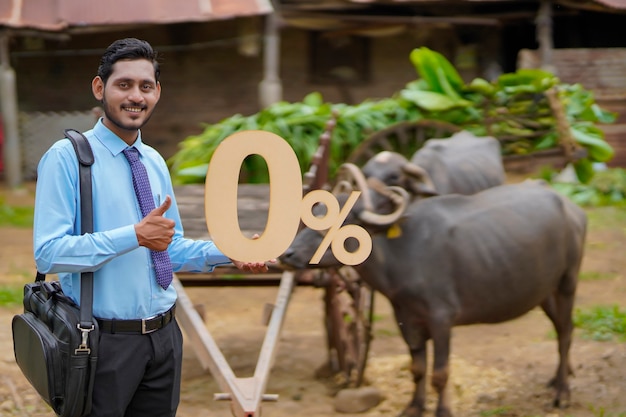 Young indian agronomist or financier showing zero percent sign or symbol at cattle farm