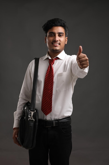 Young indian banker or business man showing expression on dark background.