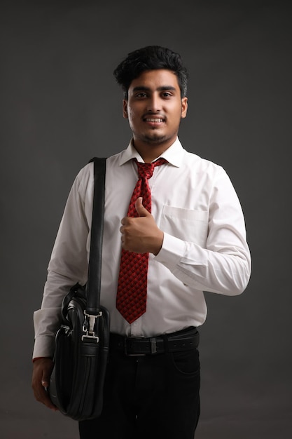 Young indian banker or business man showing expression on dark background.