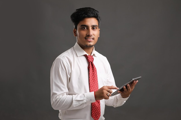 Young indian businessman or employee using smartphone.