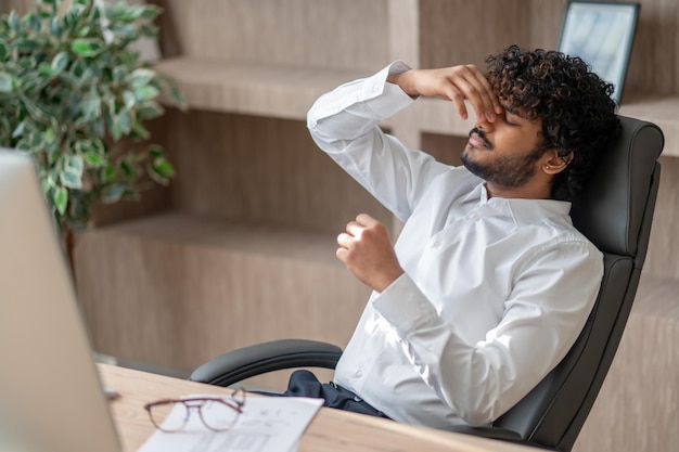 Young indian businessman looking tired