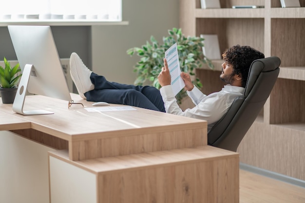 Young indian businessman sitting in the chair in the office