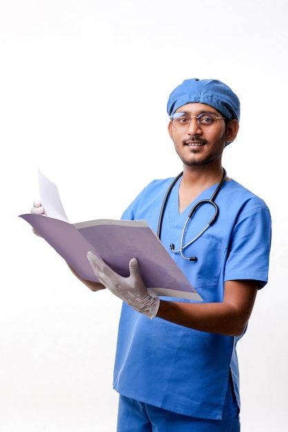 Young indian Doctor checking out some reports over white background.