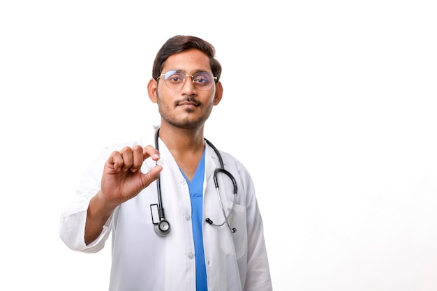 Young indian doctor holding pill in hand.