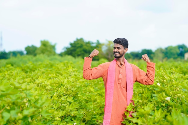 Young indian farmer at cotton agriculture field