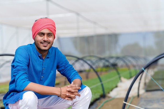 Young indian farmer at greenhouse or poly house