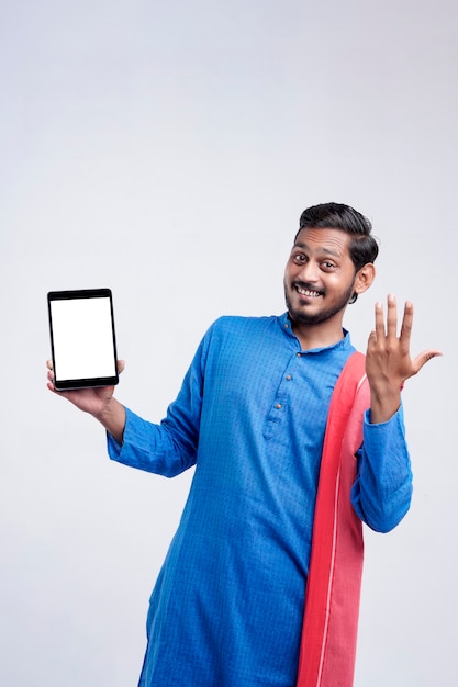 Young indian farmer showing tablet and giving expression on white background.