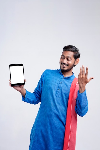 Young indian farmer showing tablet and giving expression on white background.