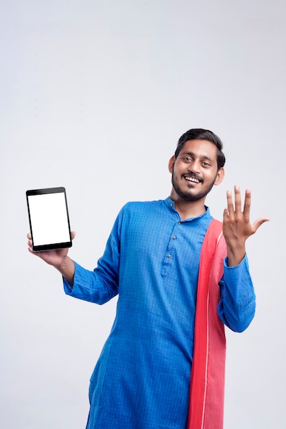 Young indian farmer showing tablet and giving expression on white background.