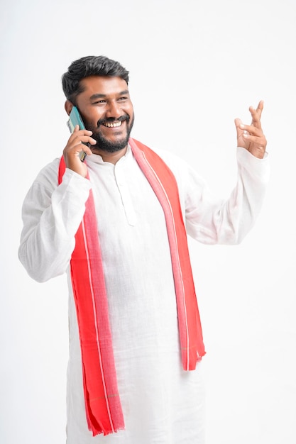 Young indian farmer talking on mobile phone over white background