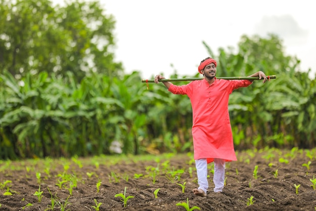 Young indian farmer in a traditional costume on the field