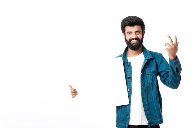 Young Indian male showing blank signboard on white background