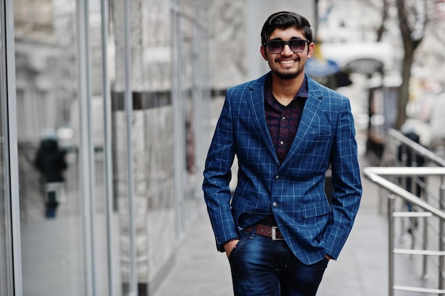 Young indian man on blue suit and sunglasses posed outdoor