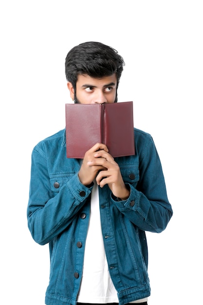 Young Indian man holding dairy in hand on white background