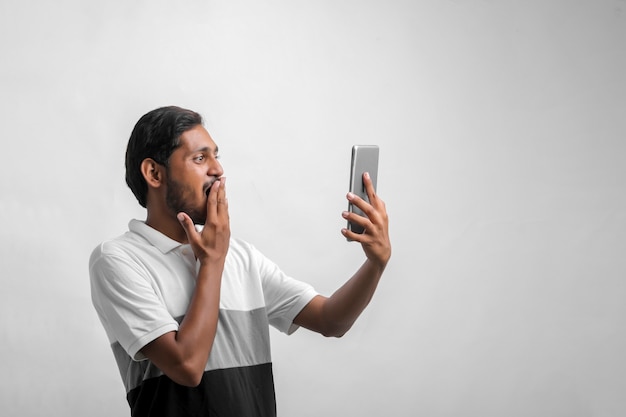 Young indian man shocking expression with smartphone