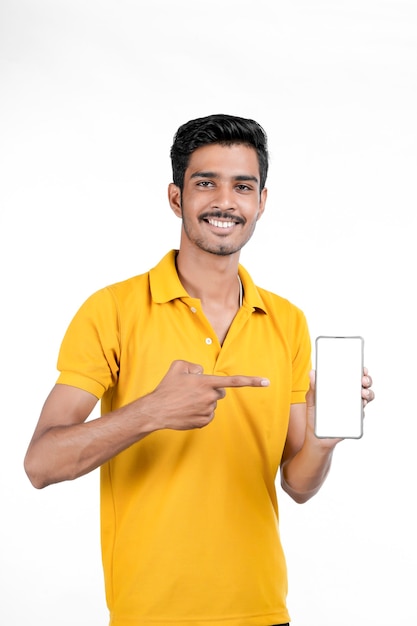 Young indian man showing smartphone on white background