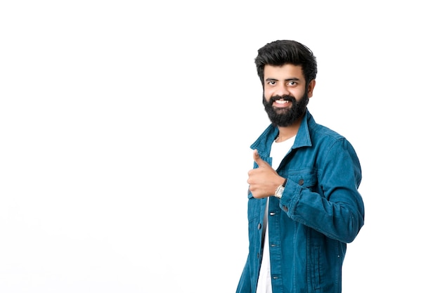 Young indian man showing thumps up and giving expression over white background