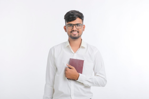 Young Indian man standing and holding dairy in hand on white background.