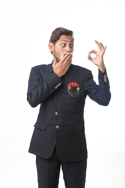 Young indian man in traditional wear and giving expression on white background.