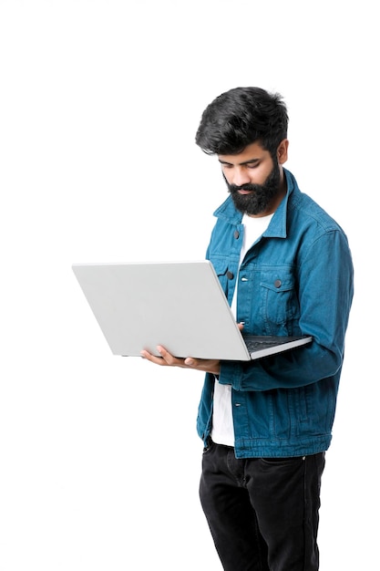 Young indian man using laptop on white background