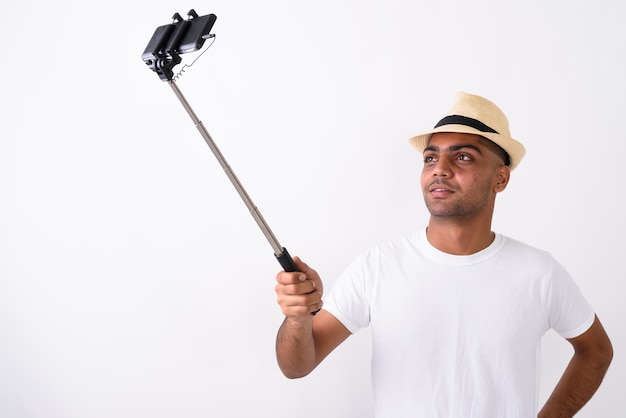 Young Indian tourist man wearing hat on white