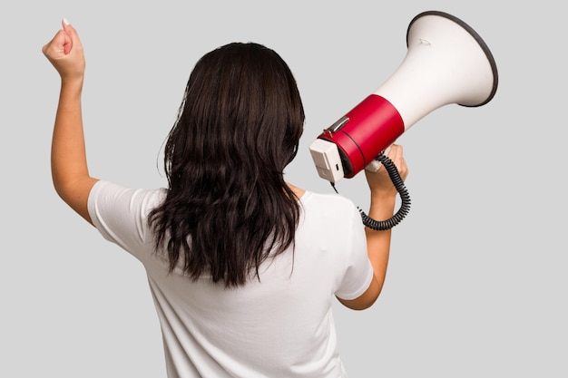 Young Indian woman holding a megaphone isolated