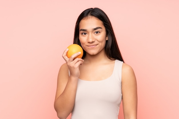 Young Indian woman holding an orange