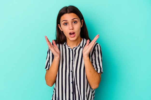 Young Indian woman isolated on blue background surprised and shocked.